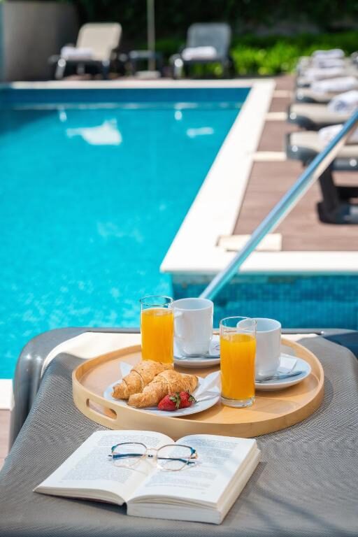 Breakfast tray with croissants and juice by the pool